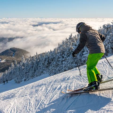 skier skiing over clouds