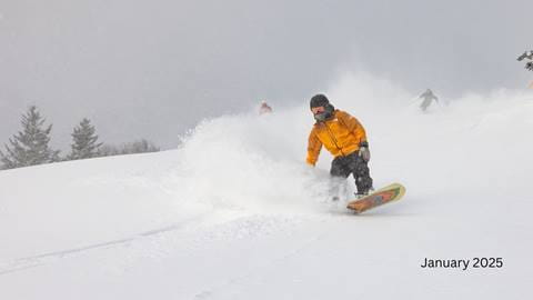 Women skiing powder in a blue jacket 