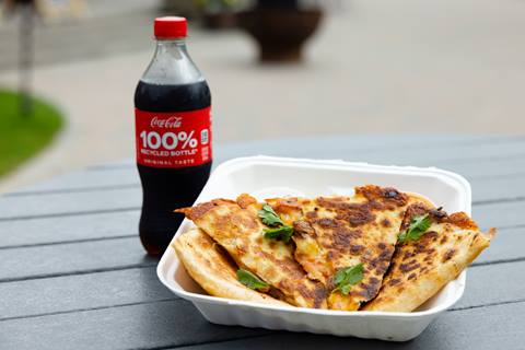 quesadilla garnished with herbs and a coca cola