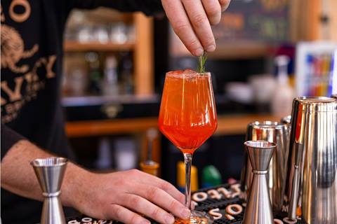bartender garnishing orange cocktail