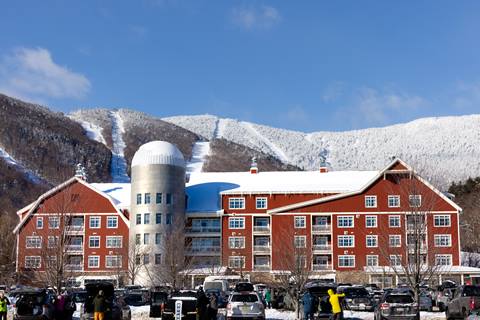 exterior of clay brook hotel from parking lot with frosted mountain behind