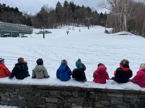 Day School Kids sitting on wall in the snow