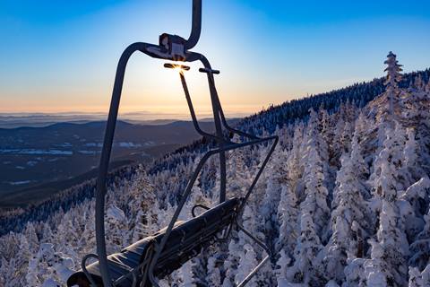 empty chairlift with sunset mountain view