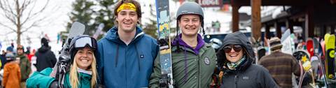 four friends smiling in the courtyard with ski gear on