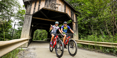 bikers riding under covered bridge