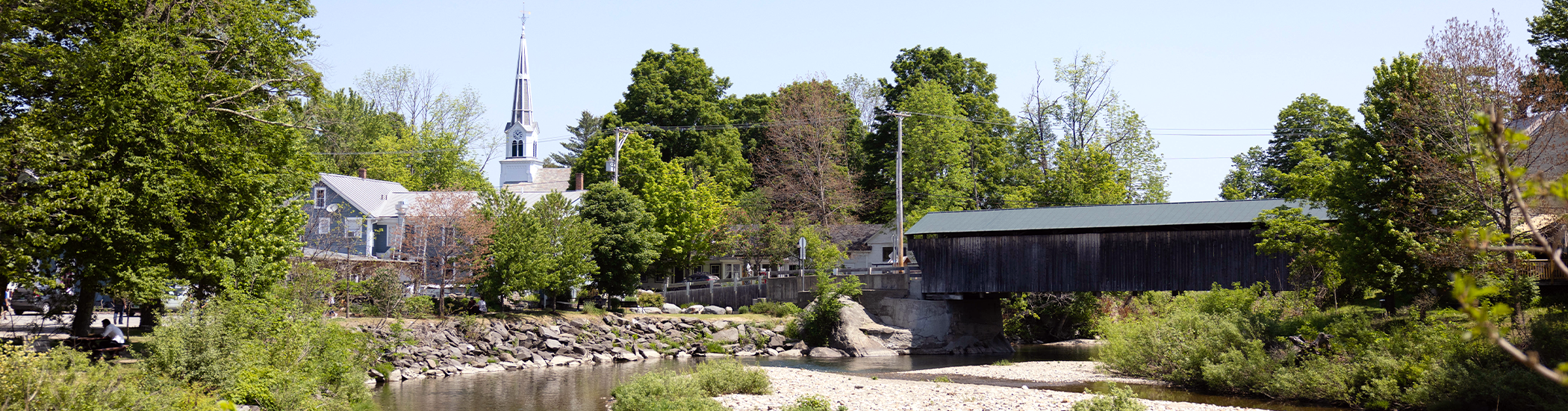 view of church steeple and covered bridge from the river in waitsfield